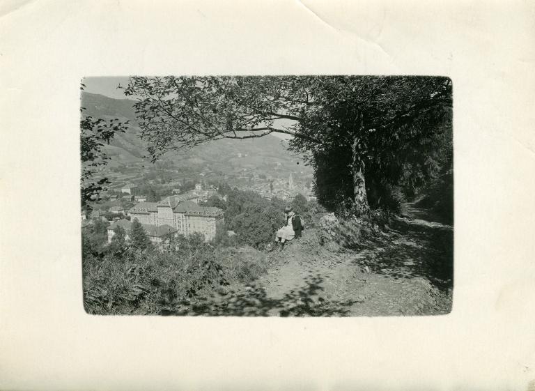 Enfant assis au bord de la route de Montouvrard. Au loin, les hôtels Splendid et Ermitage.