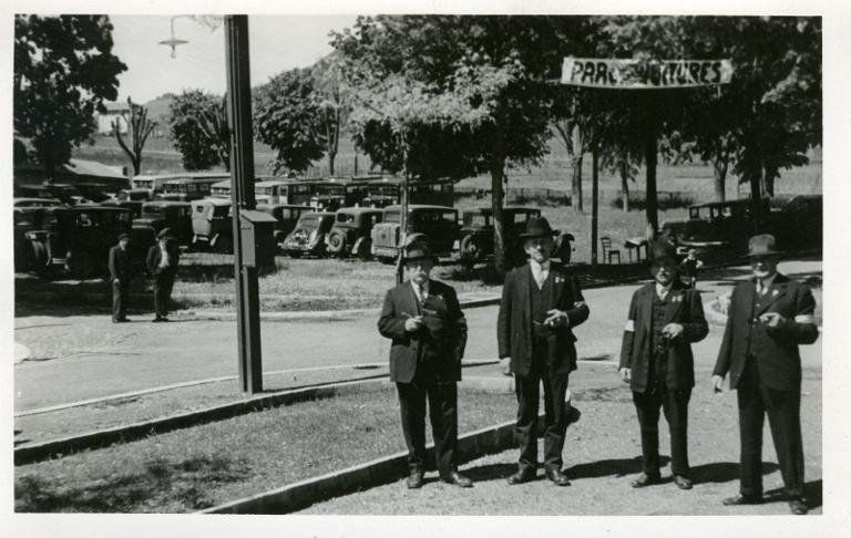Quatre hommes devant un parking