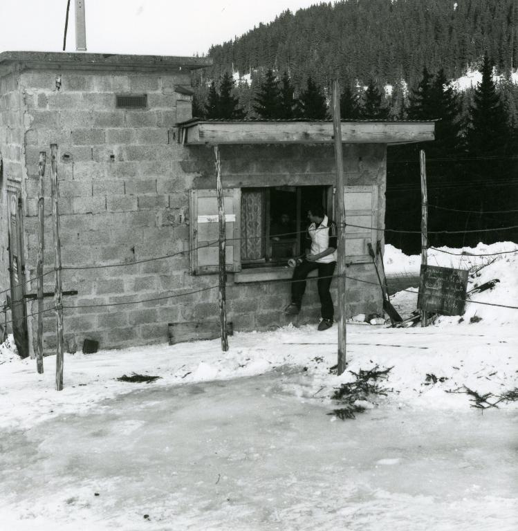 Deux hommes discutant à la fenêtre d'un cabaon de téléski